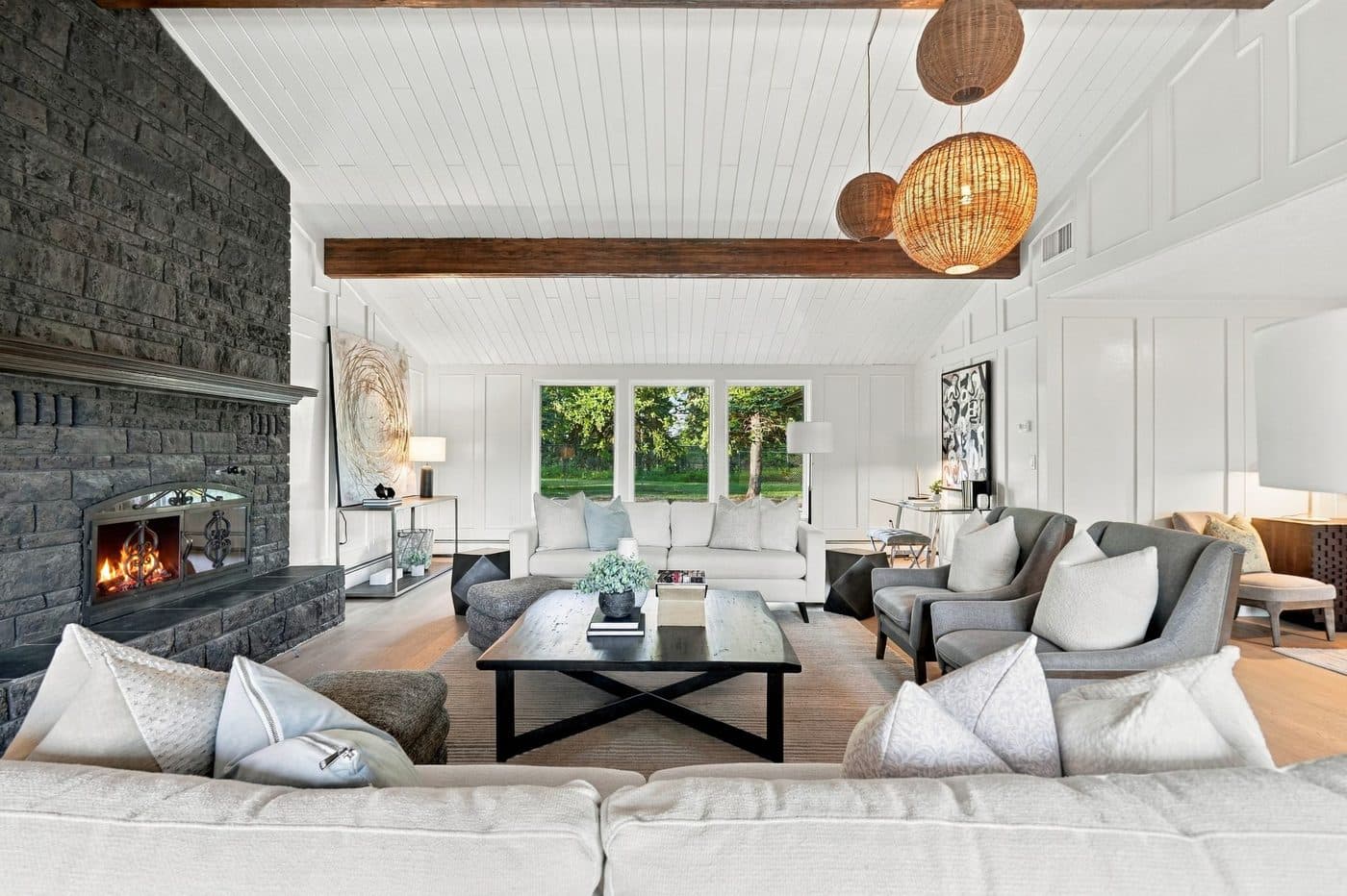 Vaulted living room with floor-to-ceiling stone fireplace